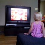 Little girl in front of a big TV